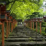 新緑の下、朱色の灯籠が両側に並ぶ京都の貴船神社の石段