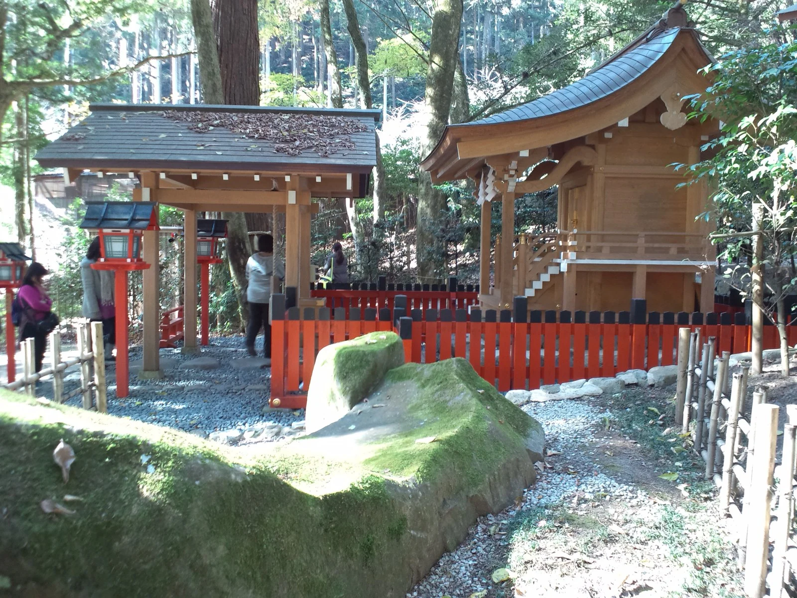 貴船神社の結社に立つ社殿と鳥居、手前の苔むした岩